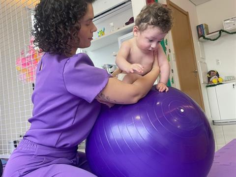 Laura, fisioterapeuta da Clínica AmarElo, em atendimento com bola suíça